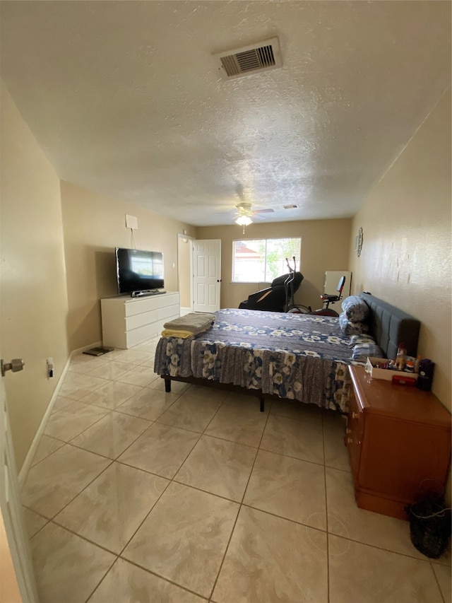 tiled bedroom featuring a textured ceiling and ceiling fan