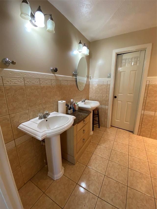 15810 Amapola Dr, Houston, TX 77083 - bathroom with wainscoting, tile patterned flooring, a sink, and tile walls