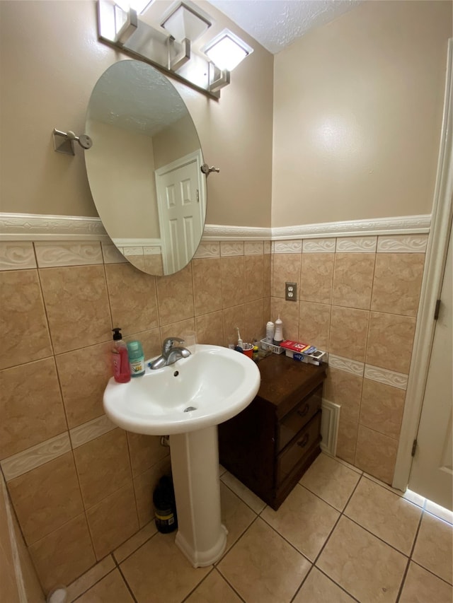 bathroom with tile patterned floors, tile walls, and a textured ceiling