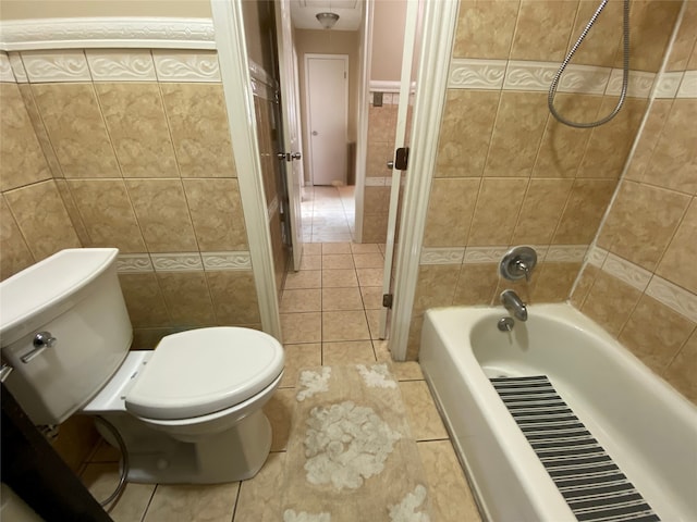 bathroom with toilet, tiled shower / bath, tile walls, and tile patterned flooring