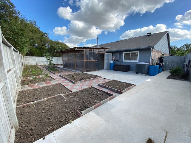 15810 Amapola Dr, Houston, TX 77083 - rear view of property with a shingled roof, a fenced backyard, a garden, central AC, and a patio area