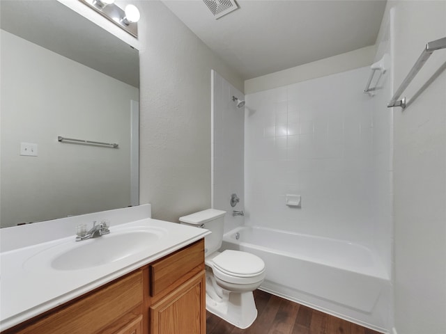 full bathroom with toilet, tiled shower / bath, hardwood / wood-style flooring, and vanity