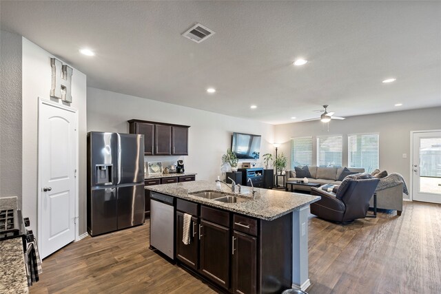 kitchen featuring light stone counters, sink, appliances with stainless steel finishes, and dark wood-type flooring