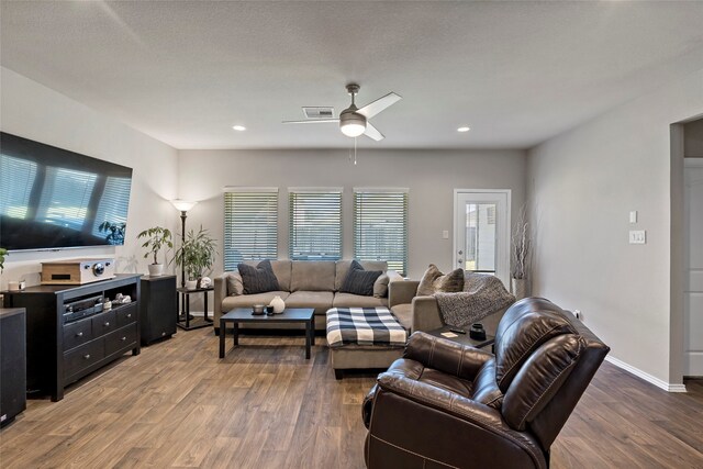 living room featuring a textured ceiling, ceiling fan, and dark hardwood / wood-style flooring