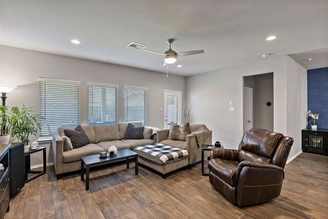 living room featuring ceiling fan and dark hardwood / wood-style flooring