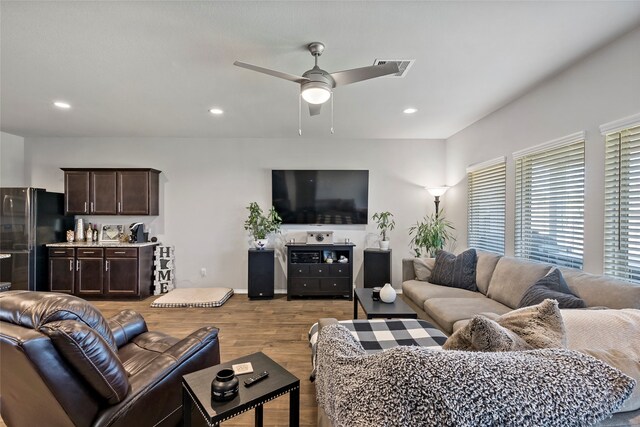 living room with light hardwood / wood-style floors and ceiling fan