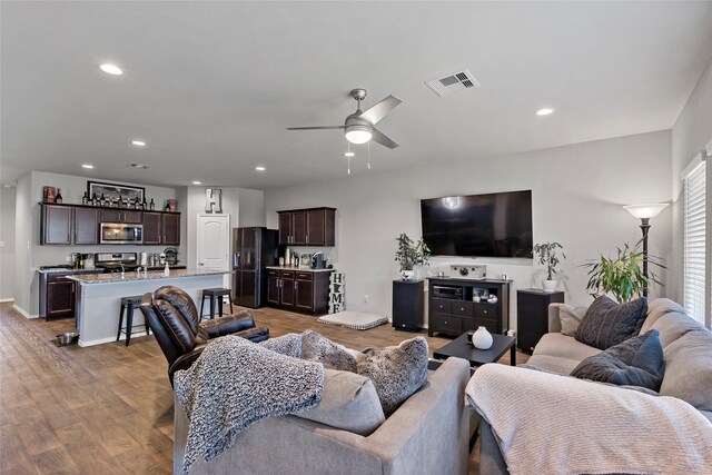 living room featuring light wood-type flooring and ceiling fan