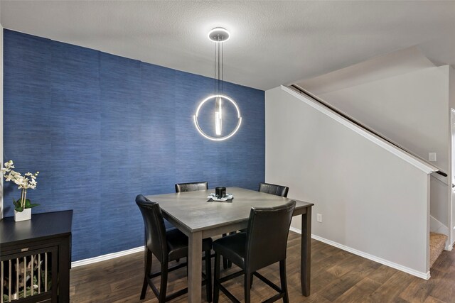 dining space featuring a textured ceiling and dark wood-type flooring