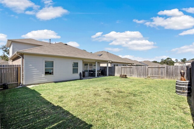 back of house featuring a patio and a lawn