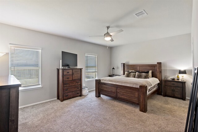 carpeted bedroom featuring ceiling fan and multiple windows