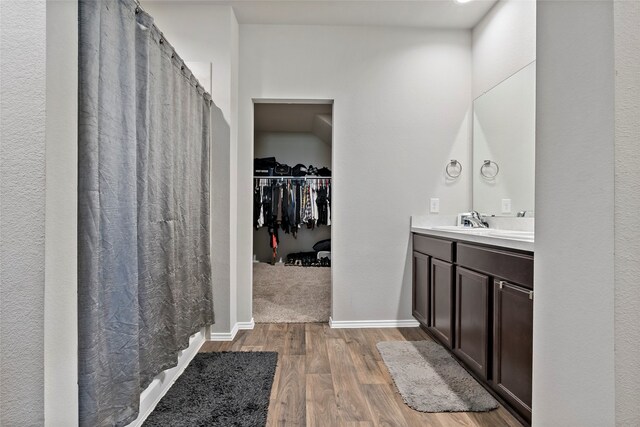 bathroom featuring vanity, wood-type flooring, and walk in shower