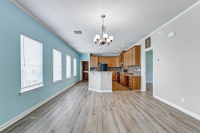 kitchen featuring a center island, decorative light fixtures, crown molding, a notable chandelier, and light hardwood / wood-style flooring