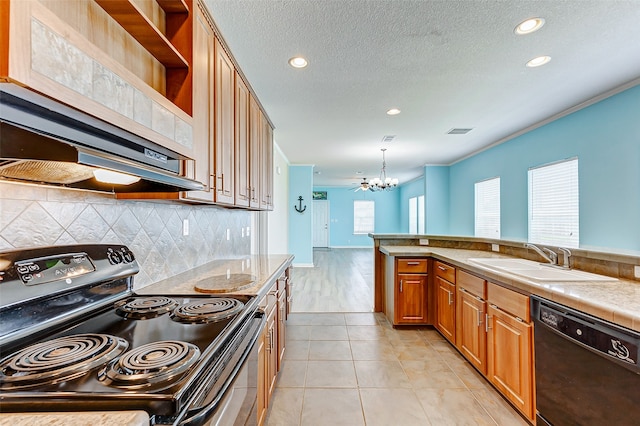 kitchen featuring black appliances, sink, pendant lighting, light tile patterned floors, and a chandelier