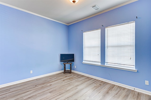 unfurnished room featuring ornamental molding and light hardwood / wood-style flooring