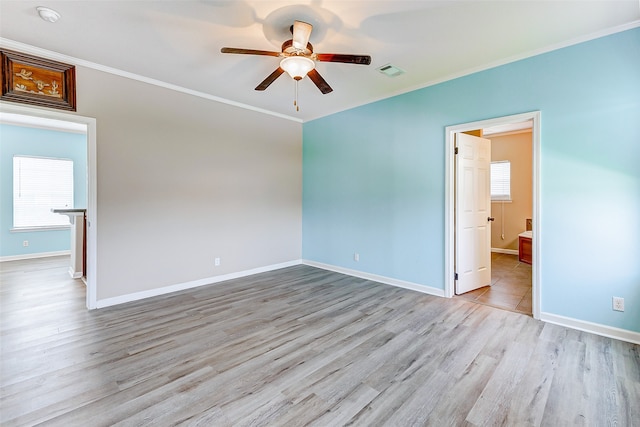 unfurnished room featuring ornamental molding, light wood-type flooring, and ceiling fan