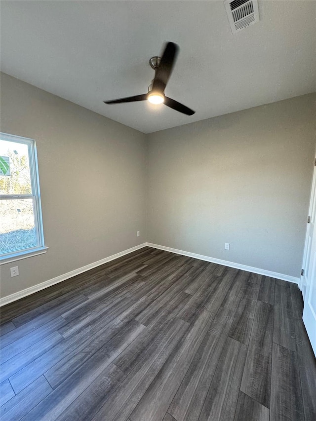 empty room with ceiling fan and dark wood-type flooring