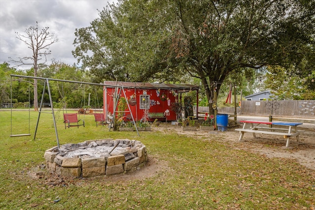 view of play area featuring a storage unit, an outdoor fire pit, and a lawn