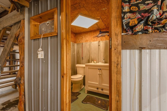 bathroom featuring a skylight, toilet, and vanity
