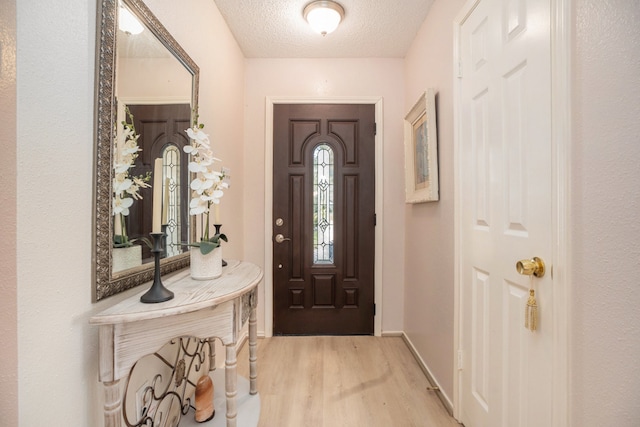 entryway featuring light hardwood / wood-style floors and a textured ceiling