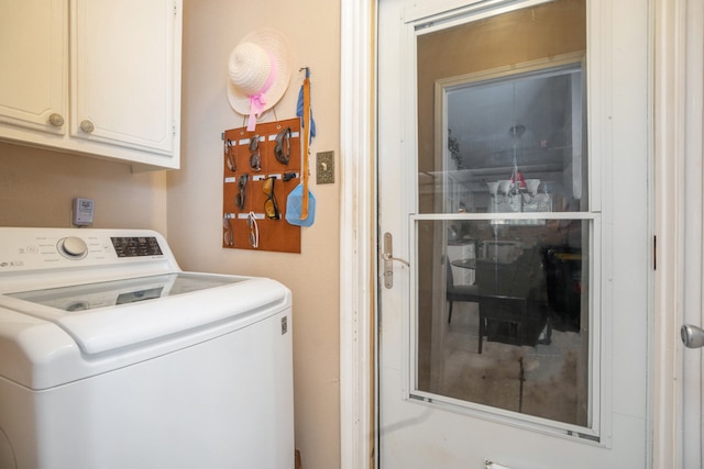 washroom featuring washer / dryer and cabinets