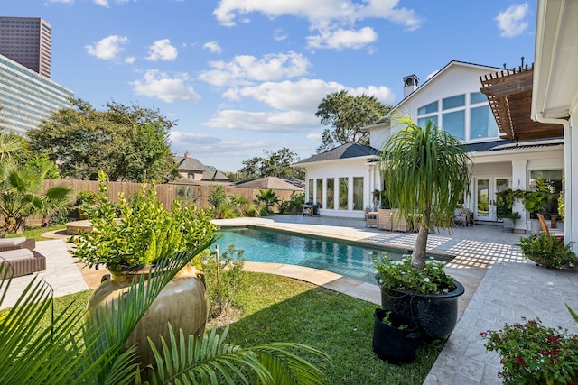 view of pool with french doors, a yard, and a patio area