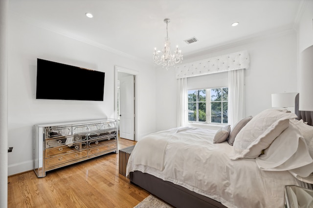 bedroom with ornamental molding, an inviting chandelier, and hardwood / wood-style floors