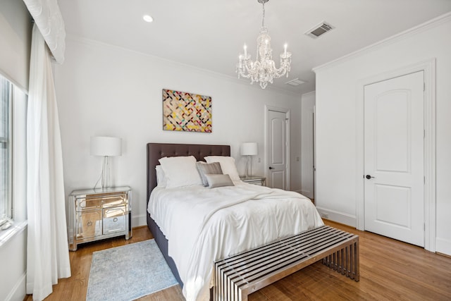 bedroom featuring ornamental molding, an inviting chandelier, and light wood-type flooring