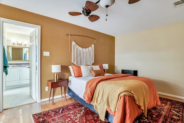 bedroom featuring hardwood / wood-style flooring, connected bathroom, and ceiling fan