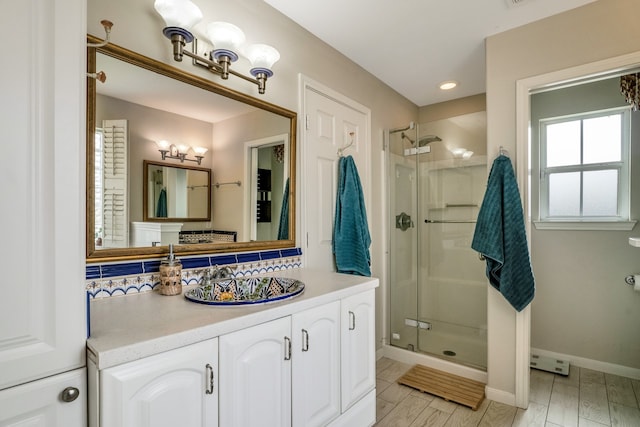 bathroom with vanity, hardwood / wood-style floors, tasteful backsplash, and a shower with shower door