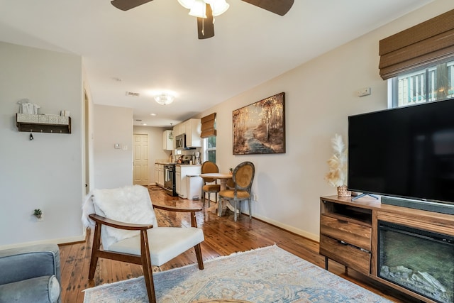 living room with hardwood / wood-style floors and ceiling fan