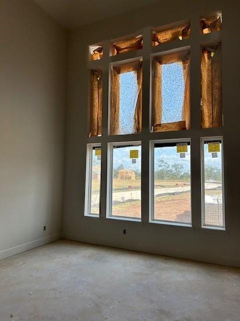 unfurnished room featuring baseboards and concrete flooring
