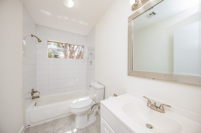 full bathroom with toilet, tiled shower / bath, vanity, and tile patterned floors