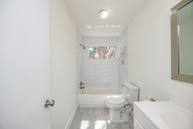 full bathroom with tiled shower / bath, vanity, and toilet