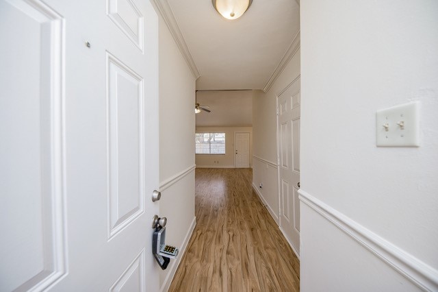 hallway featuring crown molding and light wood-type flooring