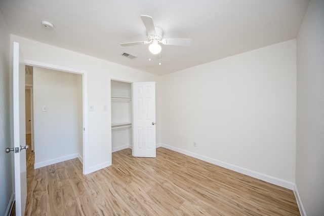 unfurnished bedroom with a closet, ceiling fan, and light wood-type flooring