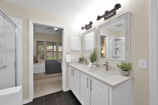 bathroom with vanity, an enclosed shower, a textured ceiling, and tile patterned floors