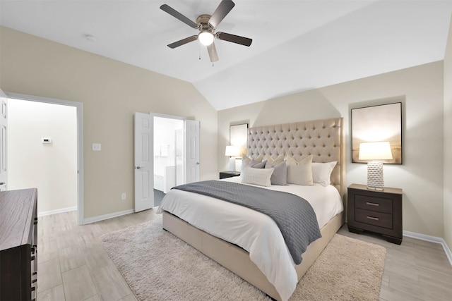 bedroom with lofted ceiling, connected bathroom, light wood-type flooring, and ceiling fan