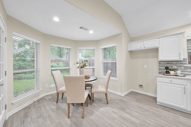 dining space featuring lofted ceiling, light hardwood / wood-style floors, and plenty of natural light