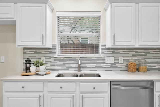 kitchen with stainless steel dishwasher, sink, and white cabinetry