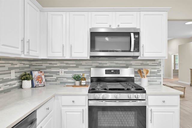 kitchen featuring white cabinets, tasteful backsplash, and stainless steel appliances