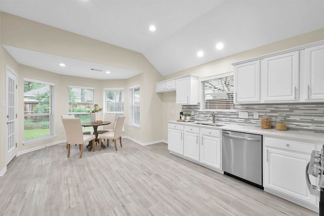 kitchen with white cabinets, tasteful backsplash, stainless steel appliances, and vaulted ceiling