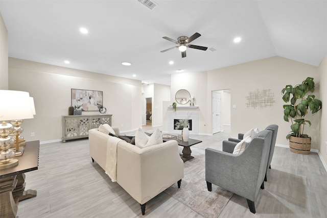 living room with light hardwood / wood-style floors, lofted ceiling, a fireplace, and ceiling fan