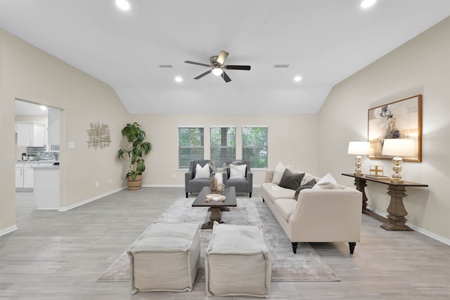 living room with light hardwood / wood-style flooring, vaulted ceiling, and ceiling fan