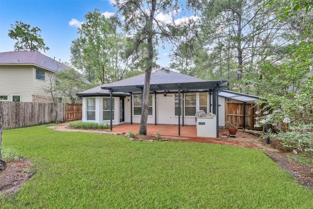 back of property with a patio, a lawn, and ceiling fan