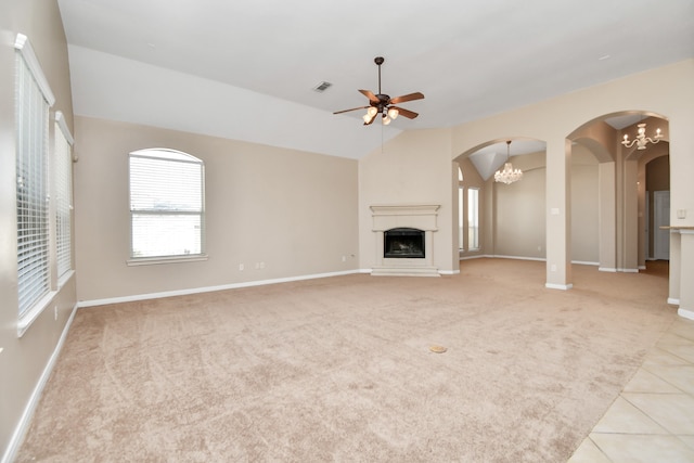 unfurnished living room with light carpet, lofted ceiling, and ceiling fan with notable chandelier