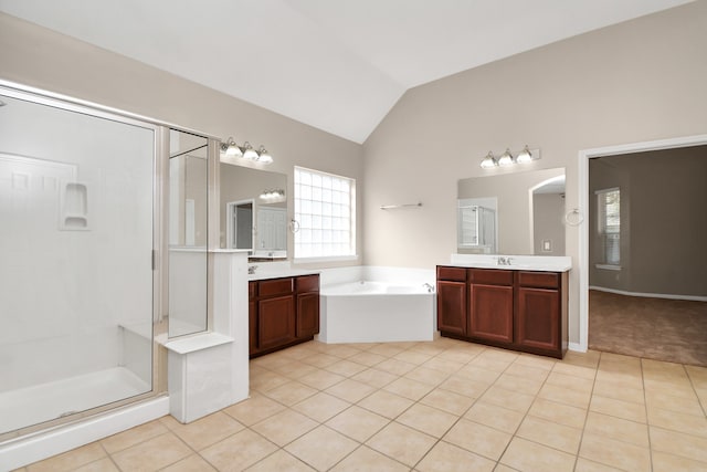 bathroom with vanity, independent shower and bath, vaulted ceiling, and tile patterned floors