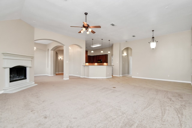 unfurnished living room featuring lofted ceiling, light colored carpet, and ceiling fan