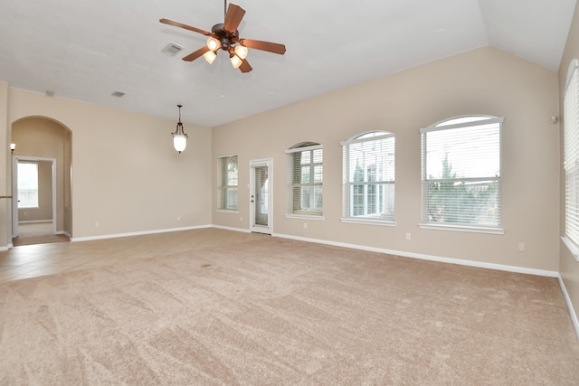 unfurnished room featuring lofted ceiling, ceiling fan, light colored carpet, and a wealth of natural light