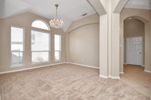 carpeted spare room with vaulted ceiling and an inviting chandelier