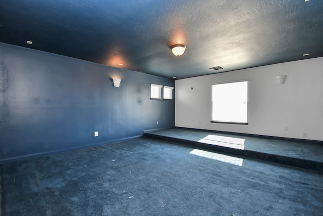 empty room featuring carpet and a textured ceiling